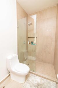 Modern bathroom interior with white toilet and glass shower.