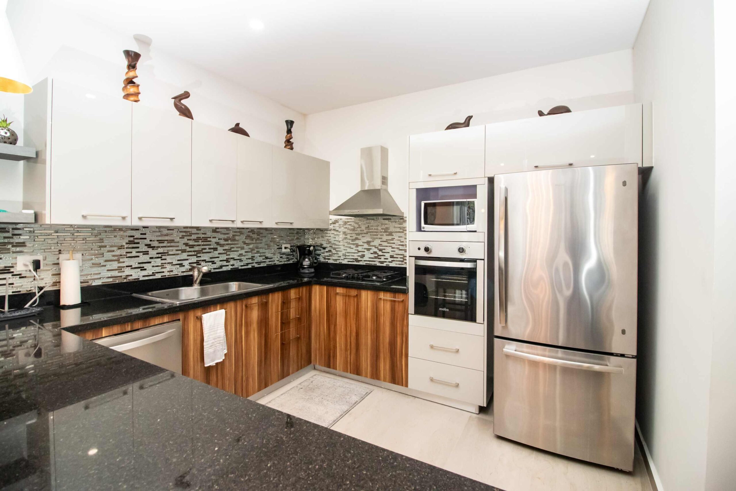 Modern kitchen interior with stainless steel appliances and wooden cabinets.